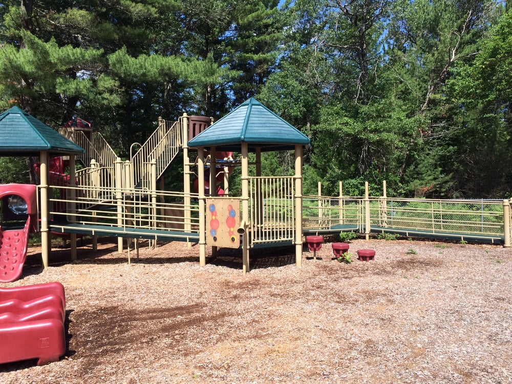 Playscape with elevated and multi-level decks and ramps that connect to tree house landings.